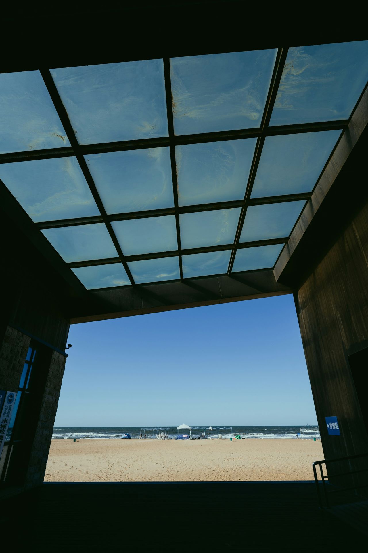 a view of a beach through a glass roof